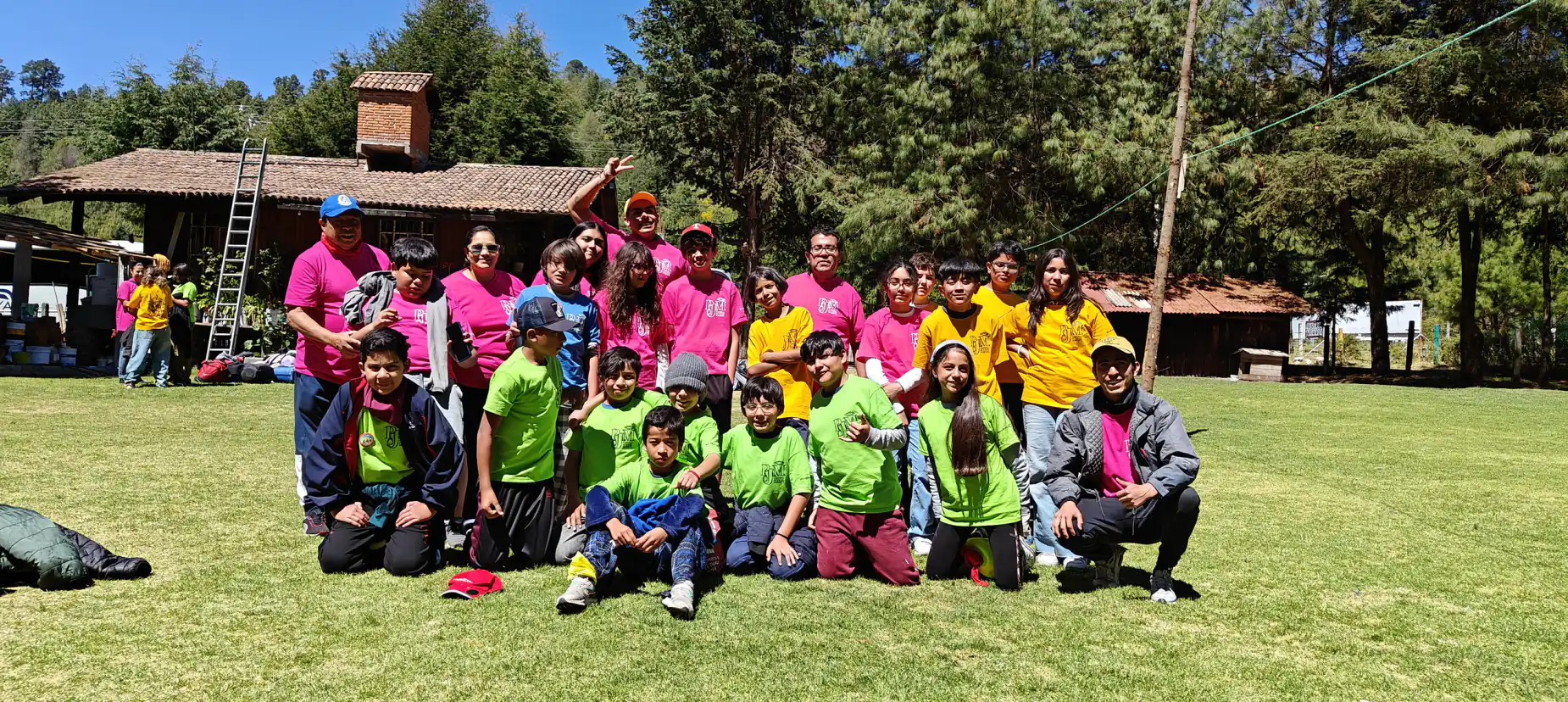 Grupo de Amigos en Marcha con playeras verdes en el campamento