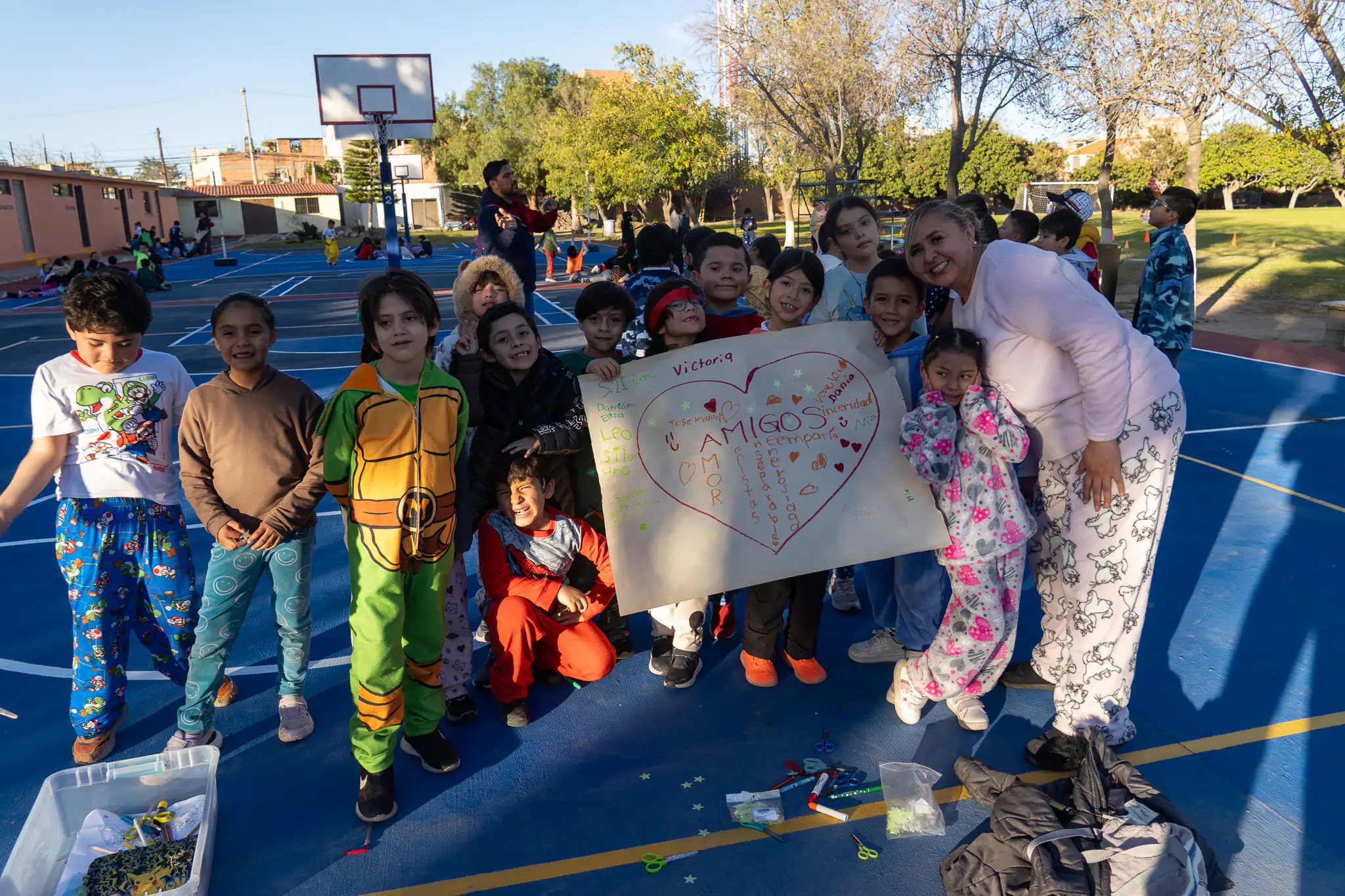 Niños mostrando un cartel hecho por ellos en la cancha