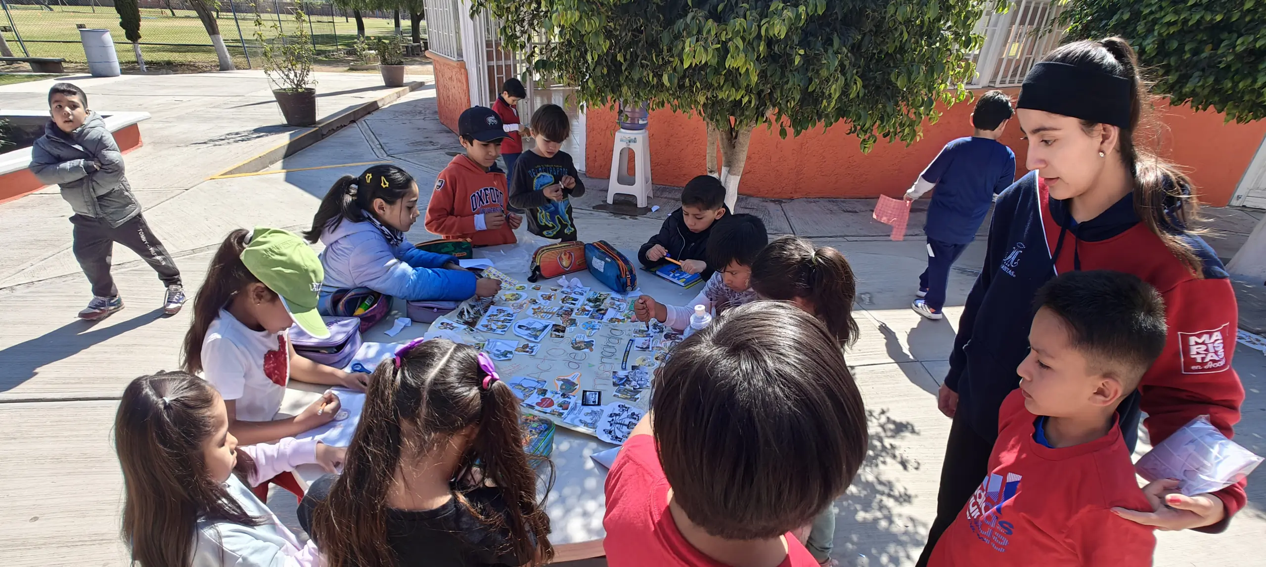 Niños dibujando en grupo sobre el piso