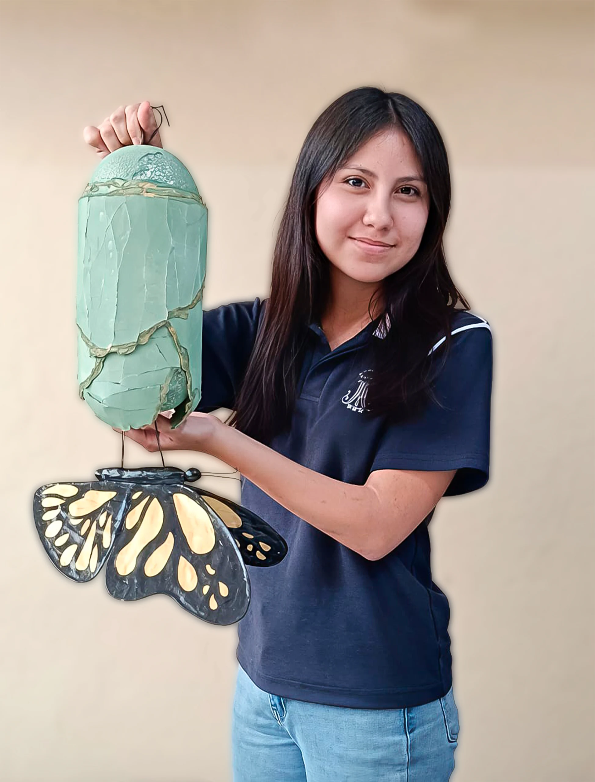 Alumna con su escultura de capullo y mariposa