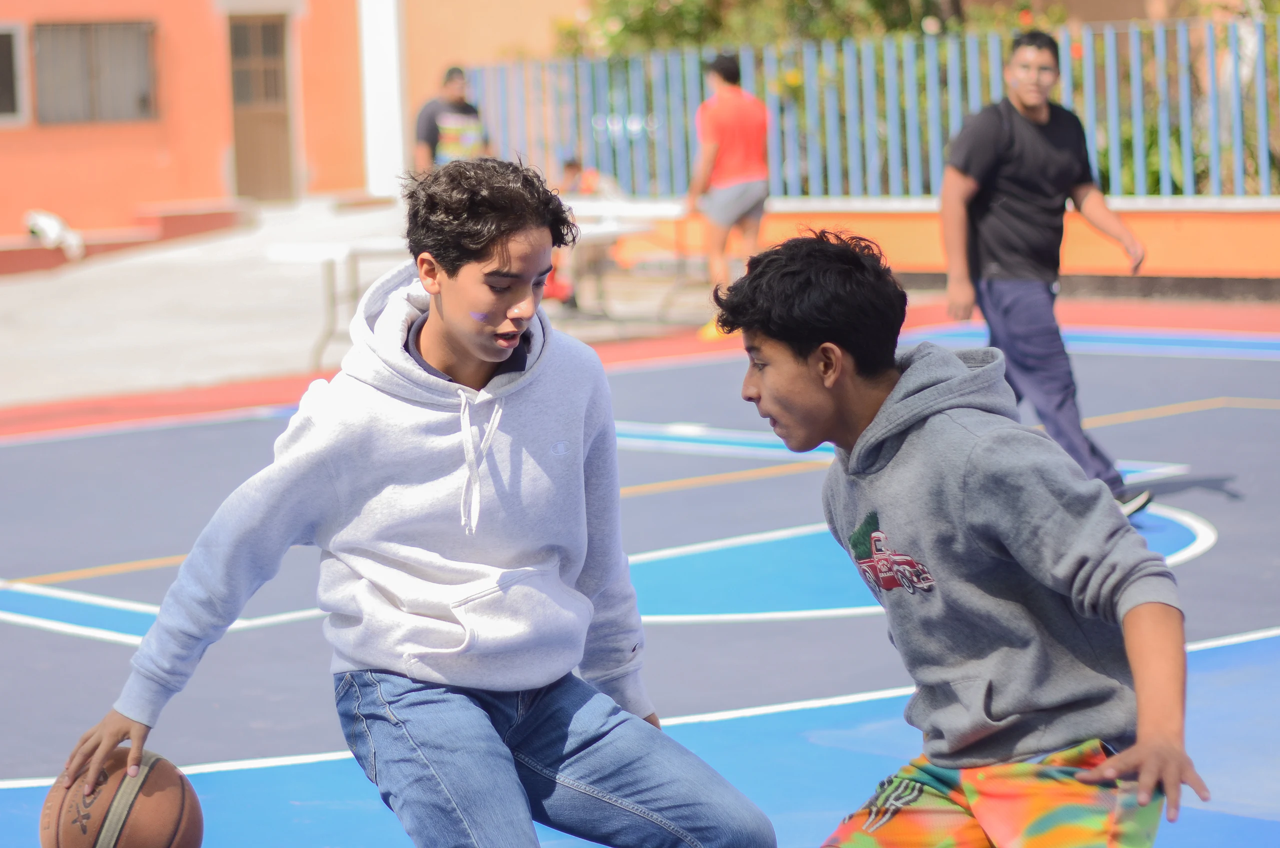 Dos alumnos disputando el balón en la cancha