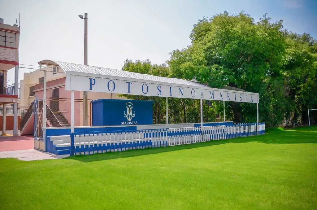 Tribuna azul y blanca con el nombre del colegio