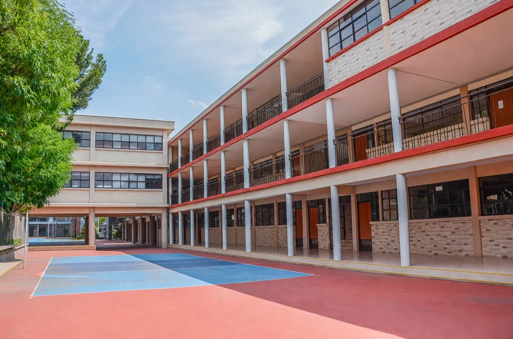 Canchas de voleibol de colores junto al edificio de tres pisos