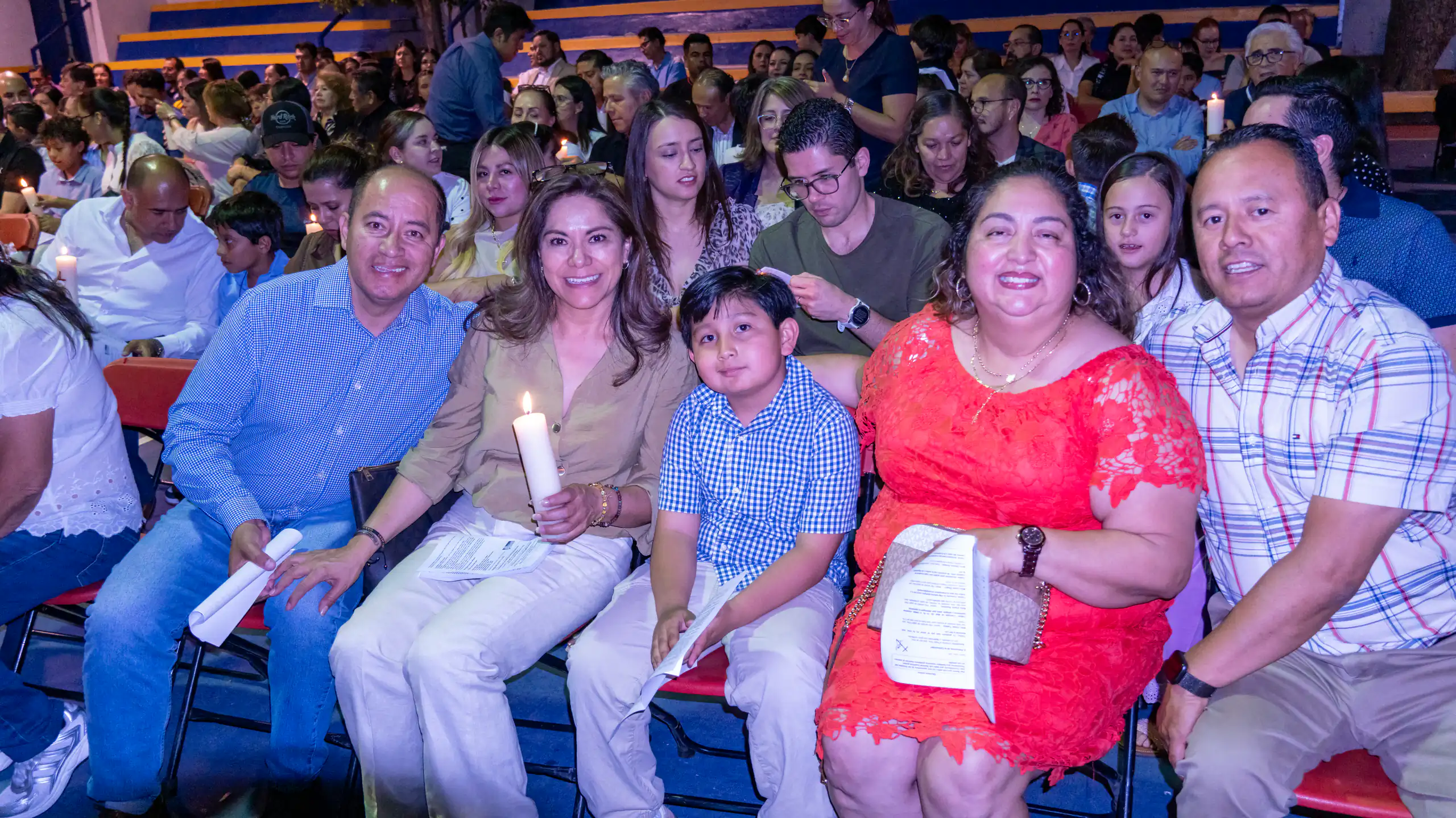 Familias sosteniendo velas durante la celebración