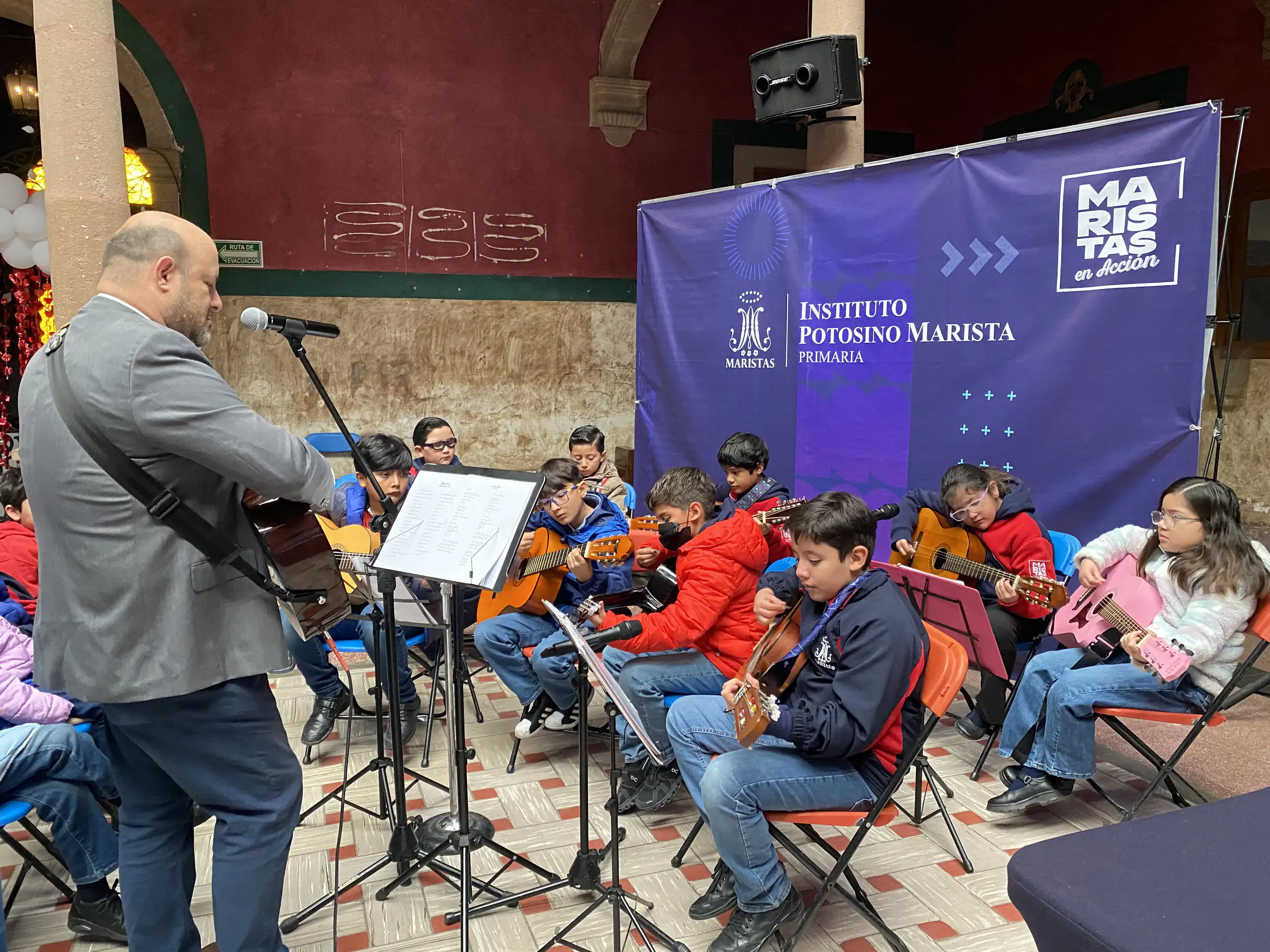 Clase de guitarra acústica con el maestro frente al grupo