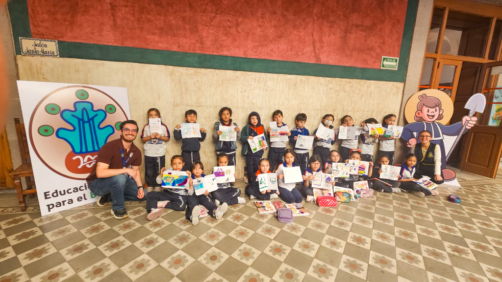 Grupo de primaria con la manta de Educación ambiental y Buen Vivir en el salón