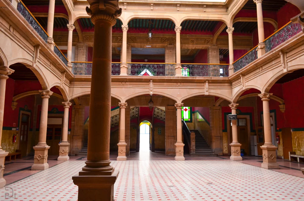 Patio central del edificio histórico de Primaria con columnas de cantera, arcos y piso de mosaico