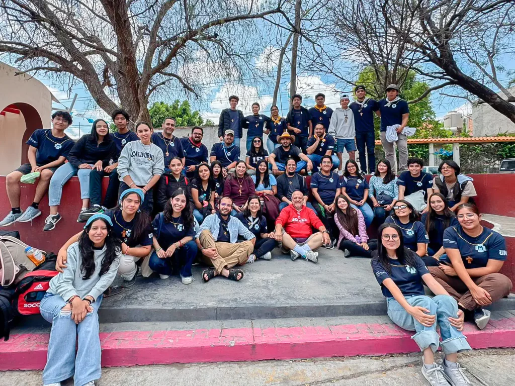 Grupo de jóvenes de la Pastoral Juvenil Marista sentados en una escalinata