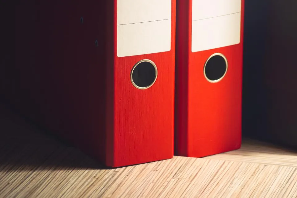 Dos archivadores rojos sobre un piso de madera