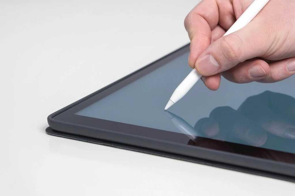 Mano firmando con un lápiz digital sobre una tableta