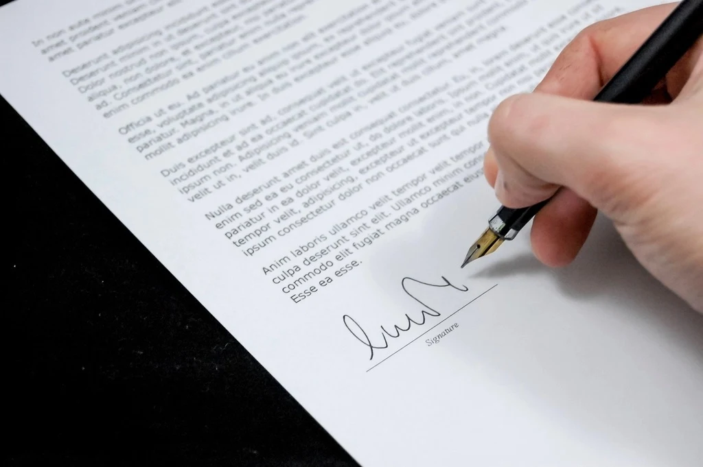 Mano firmando un documento con pluma fuente