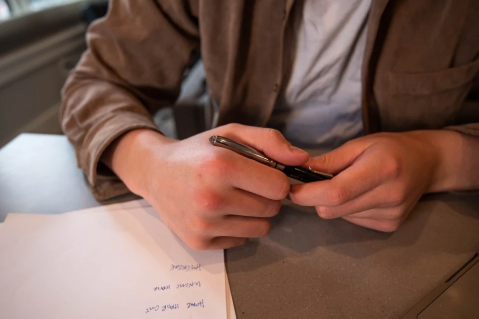 Manos rellenando un formulario sobre un escritorio