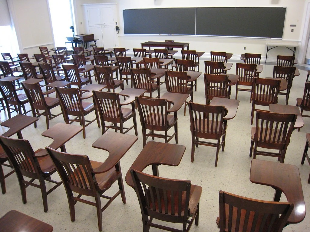 Aula vacía con sillas de madera ordenadas en filas