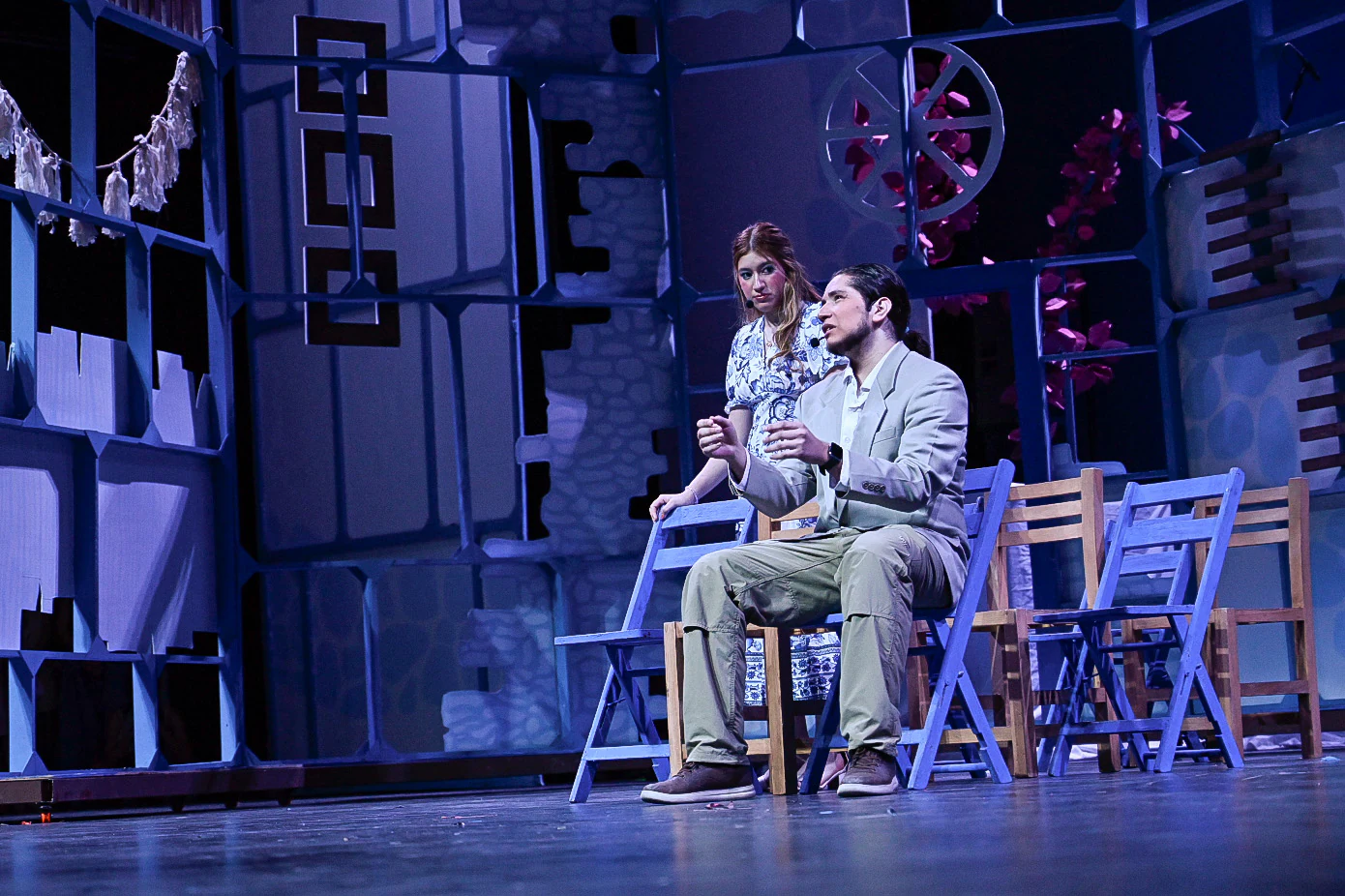 Dos actores en escena sobre escenografía de estructuras