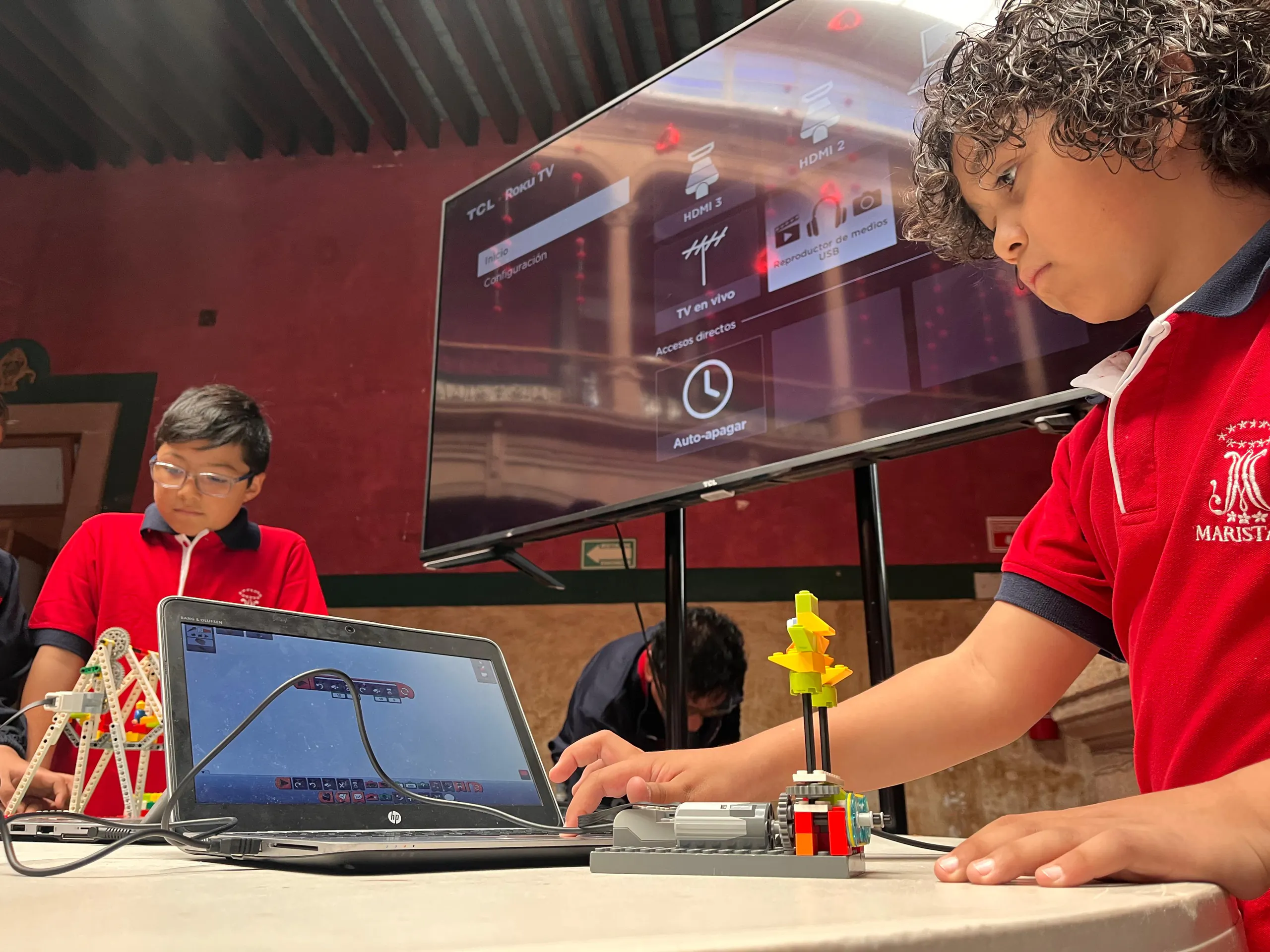 Alumno programando su robot en la laptop