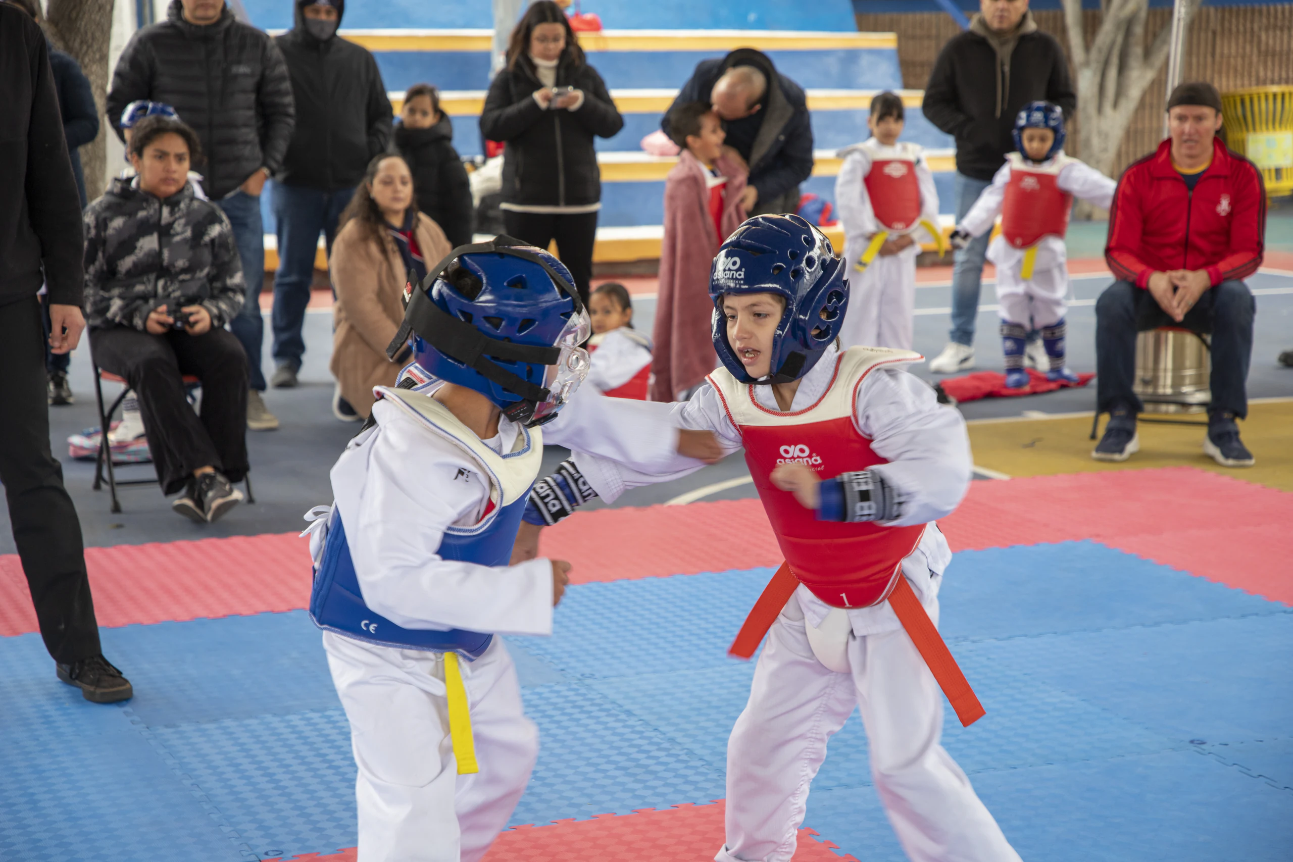 Dos alumnos en combate de taekwondo sobre el tatami