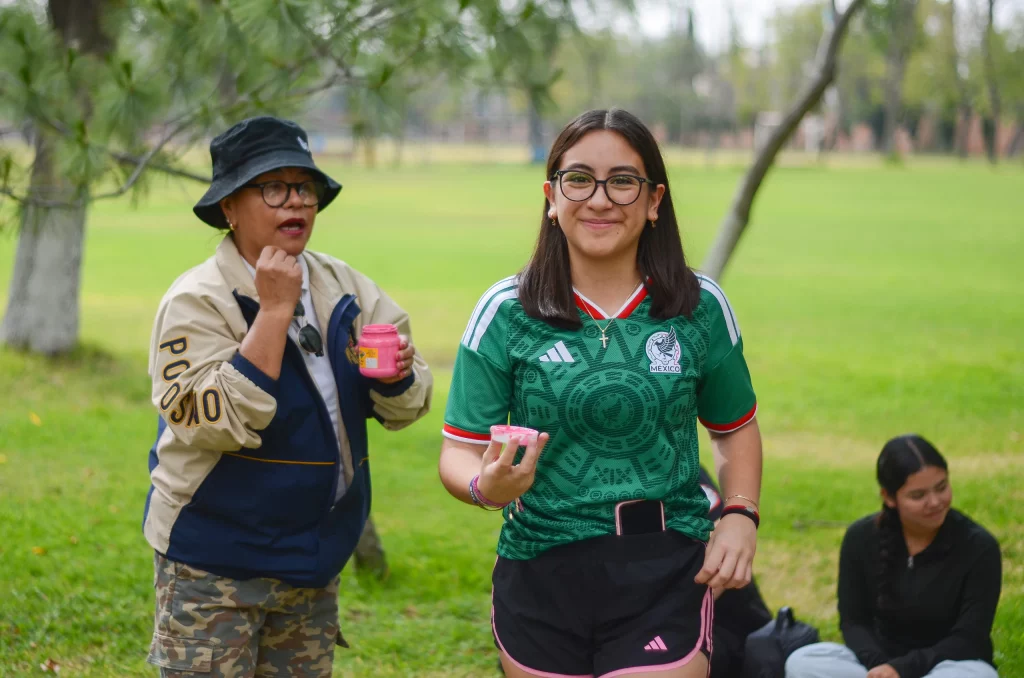 Docente y alumna conversando y riendo en el jardín