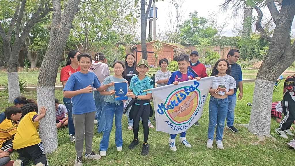 Niños de Amigos en Marcha con su estandarte al aire libre