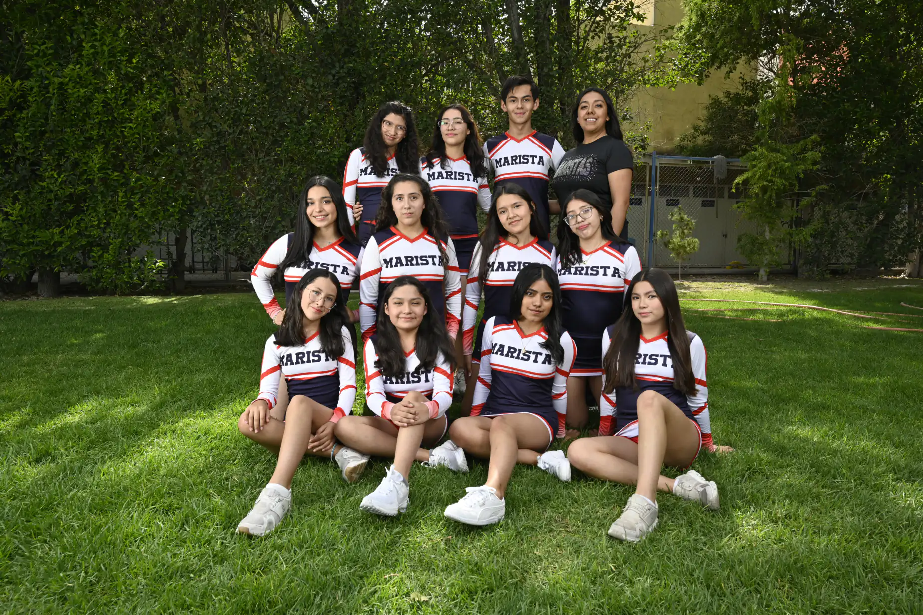 Equipo femenil de voleibol posando en el jardín